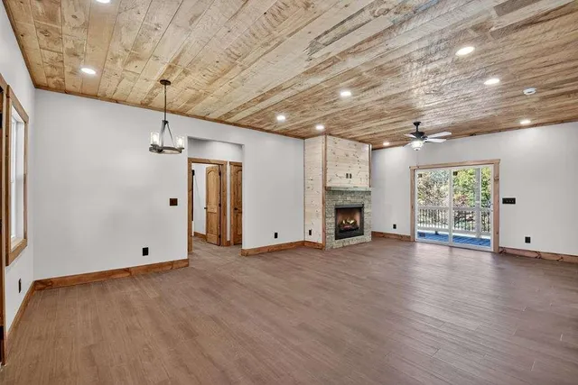 a view of empty room with wooden floor and fireplace