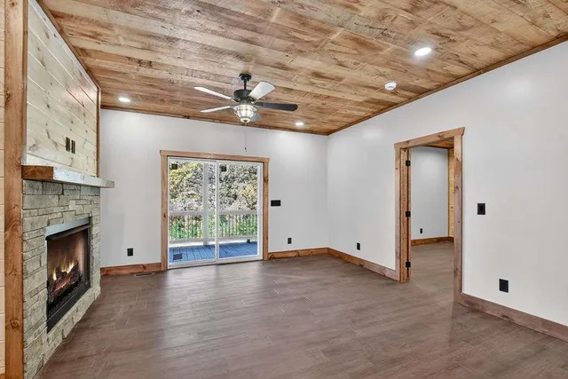 a view of an empty room with a fireplace and a window