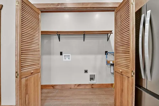 a view of a refrigerator in kitchen and an empty room