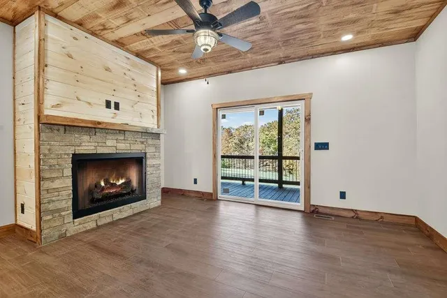 a view of an empty room with a fireplace and a window