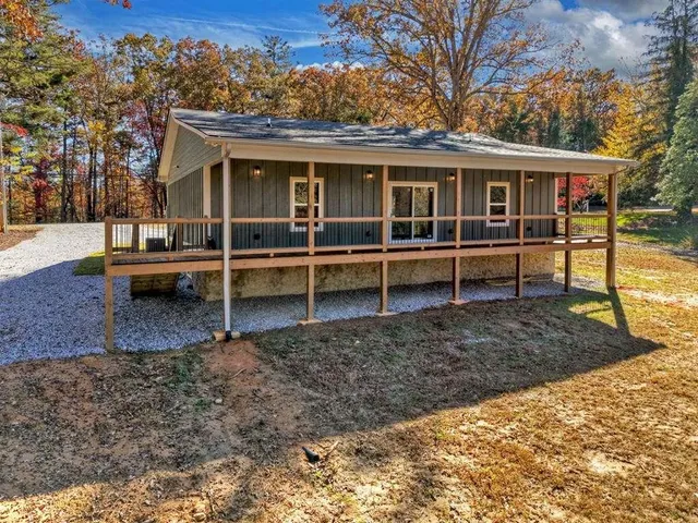 a view of house with a yard and sitting area