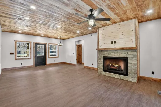 a view of an empty room with a fireplace and a window