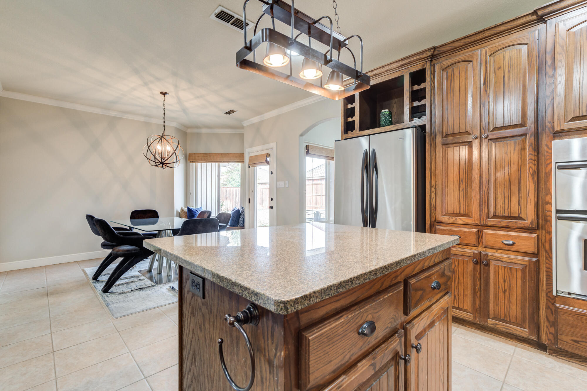 6020 85th Street Lubbock, TX 79424 - Photo 16 of 58 a kitchen with a table chairs cabinets and stainless steel appliances