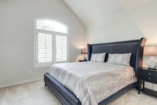a bedroom with a large bed and a chandelier