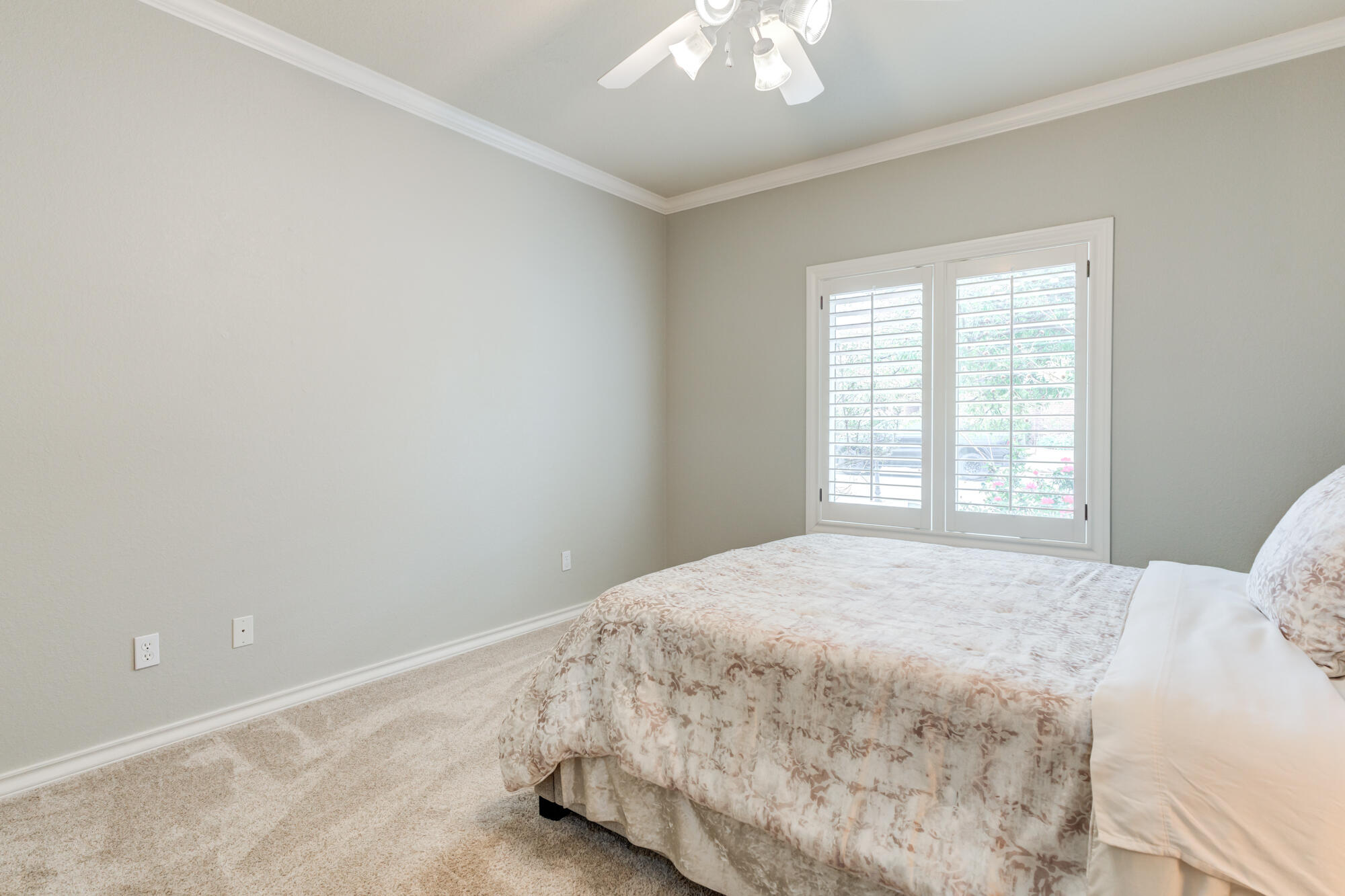 6020 85th Street Lubbock, TX 79424 - Photo 42 of 58 a bedroom with a bed and a chandelier fan