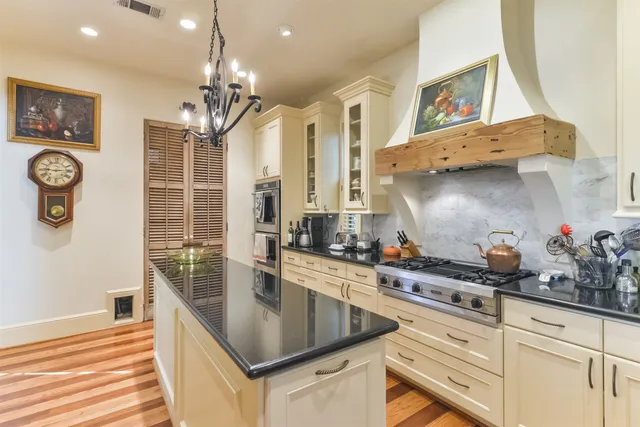 a kitchen with stainless steel appliances granite countertop a sink a stove and a wooden floors