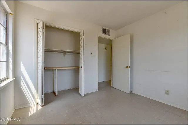 a view of walk in closet with empty racks