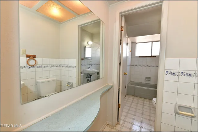 a bathroom with a granite countertop sink a mirror and shower