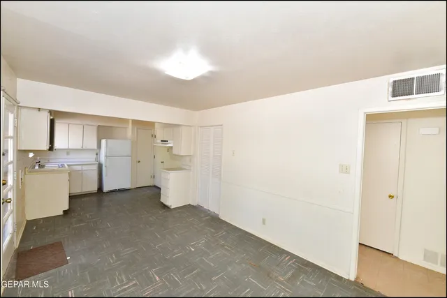 a view of a kitchen with white cabinets and wooden floor