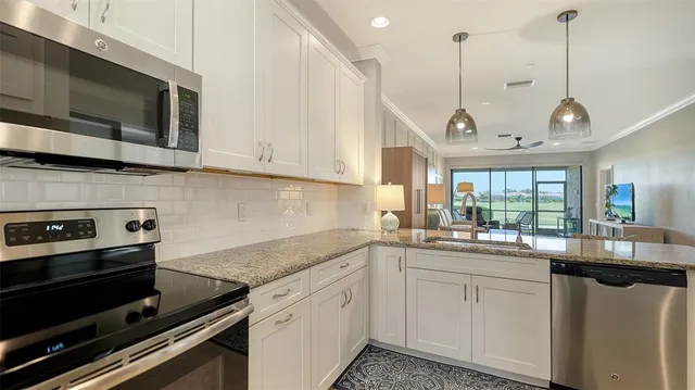 a kitchen with kitchen island granite countertop a refrigerator and a sink