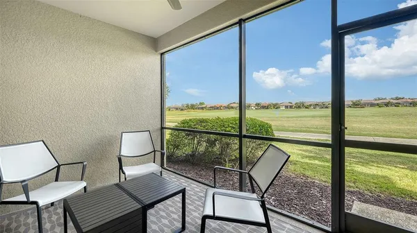 a living room with patio furniture and a chandelier