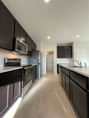 a large kitchen with stainless steel appliances and a stove top oven