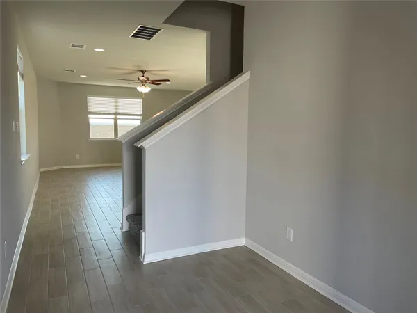a view of hallway with stairs and wooden floor