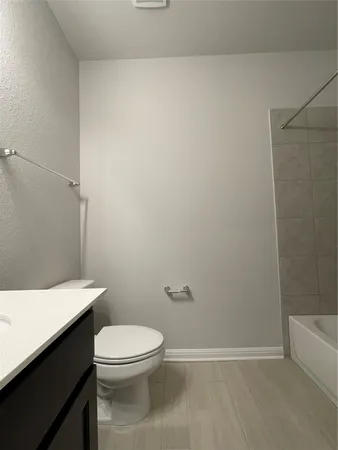 a white toilet sitting next to a bath tub