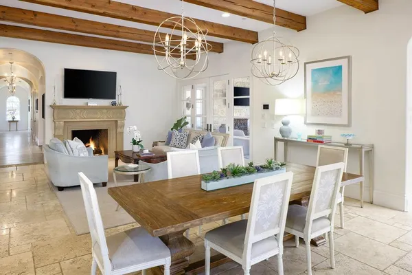 a view of a dining room with furniture a fireplace and chandelier