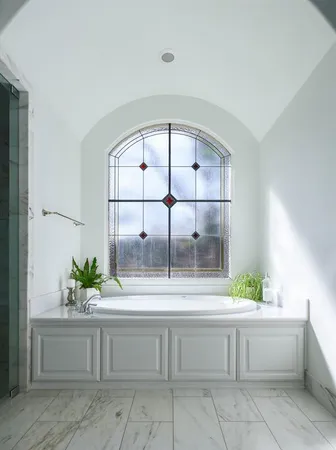 a white bath tub sitting in a bathroom with mirror