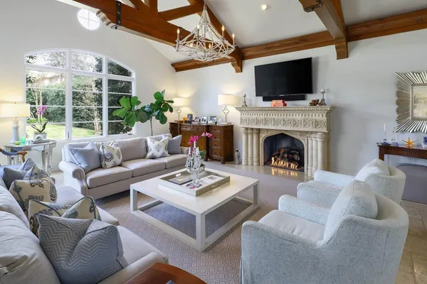 a living room with furniture a fireplace and a flat screen tv