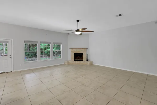 a view of an empty room with a fireplace and a window