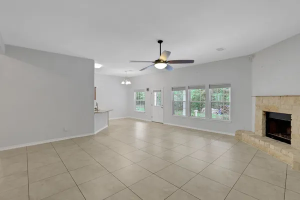 an empty room with windows and fireplace