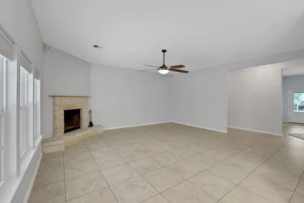 an empty room with windows and fireplace