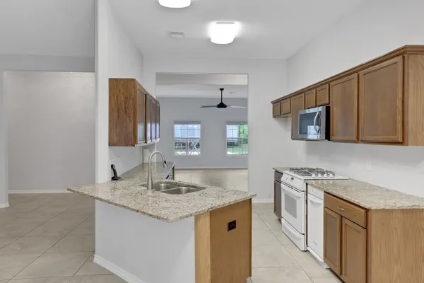 a kitchen with stainless steel appliances granite countertop a sink stove and cabinets