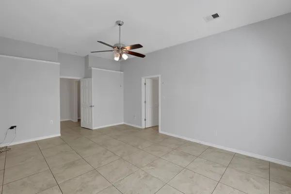 an empty room with a ceiling fan and a window
