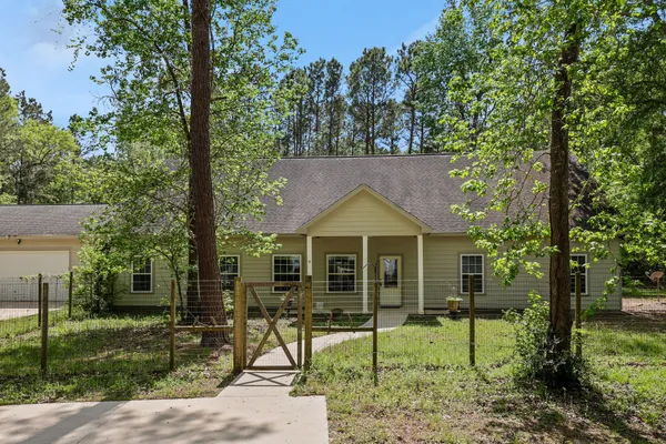 a view of a house with backyard and a tree