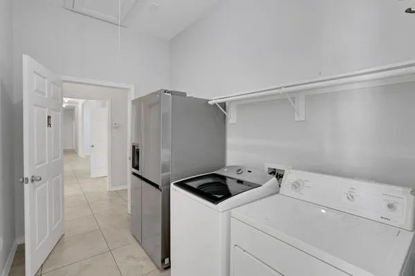 a view of a storage & utility room with refrigerator