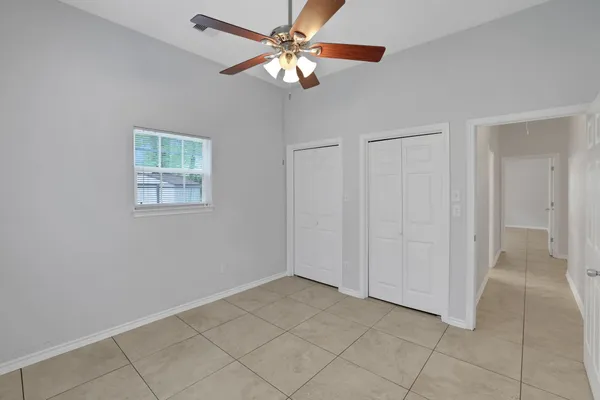 a view of an empty room and chandelier fan