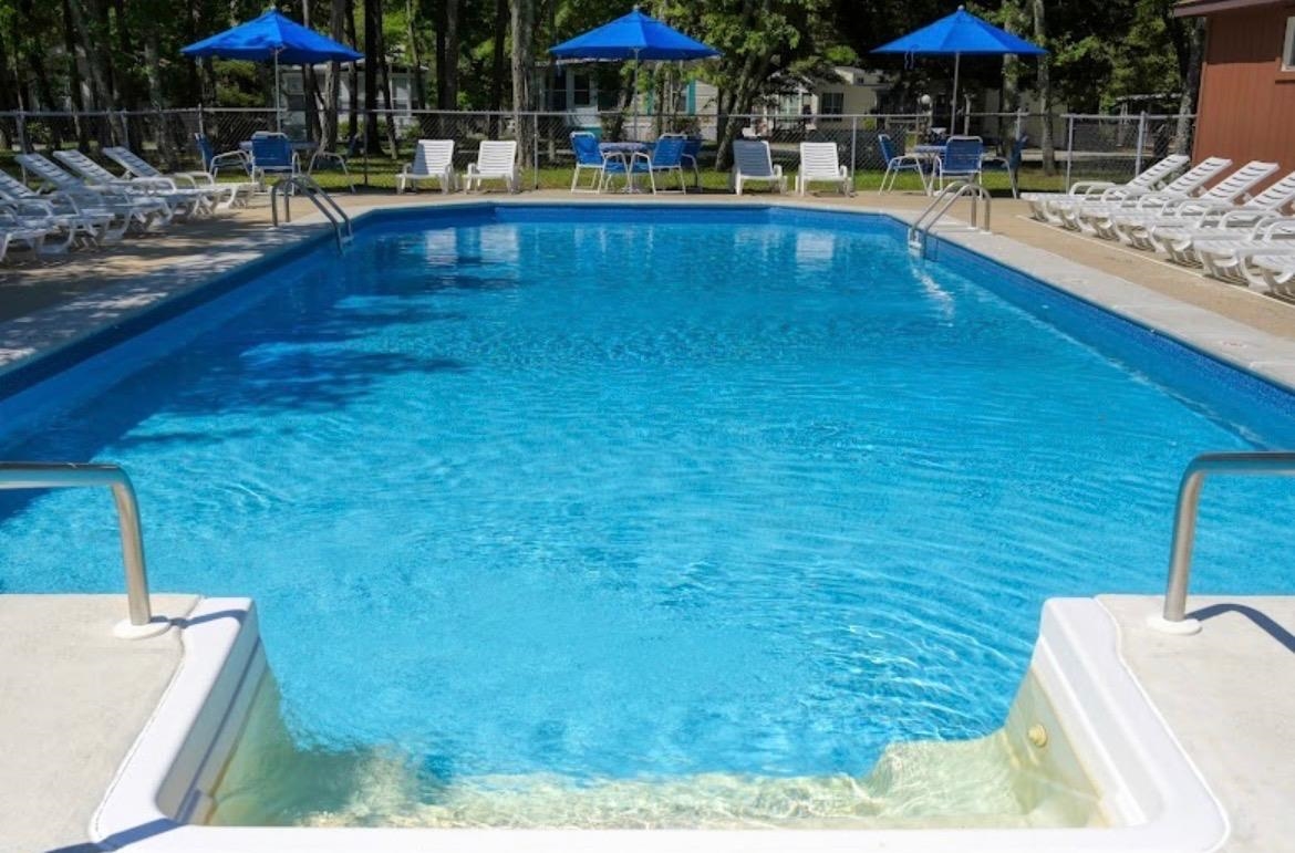 709 Seashore Road Cape May, NJ 08204 - Photo 23 of 29 a view of swimming pool with chairs and tables under an umbrella