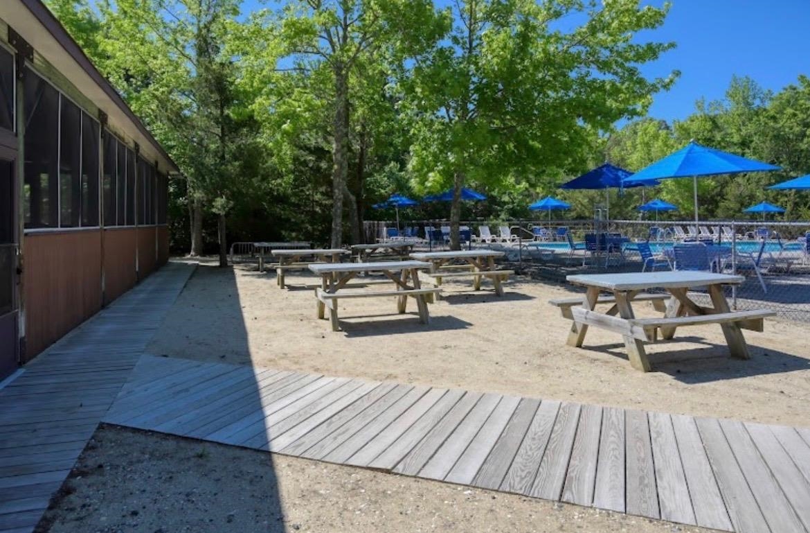 709 Seashore Road Cape May, NJ 08204 - Photo 27 of 29 a view of patio with table and chairs under an umbrella with wooden floor