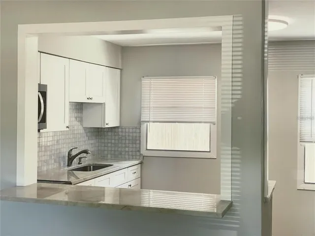 a kitchen with stainless steel appliances white cabinets and a sink
