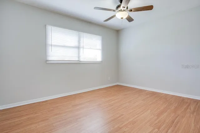 an empty room with wooden floor and door