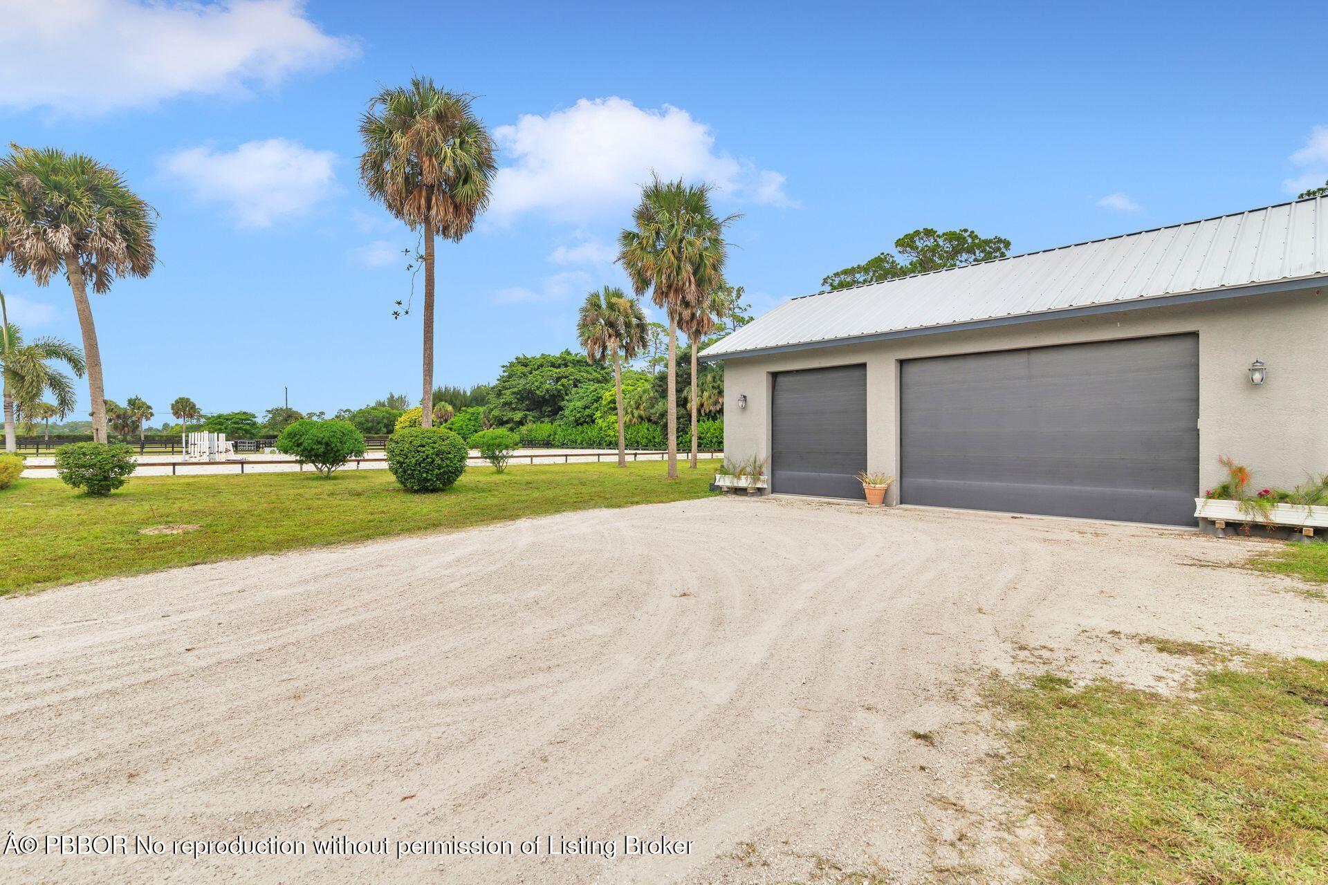 2770 E Road Loxahatchee, FL 33470 - Photo 39 of 51 a front view of a house with a yard and garage