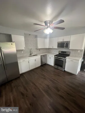 a kitchen with stainless steel appliances a stove a sink and a refrigerator