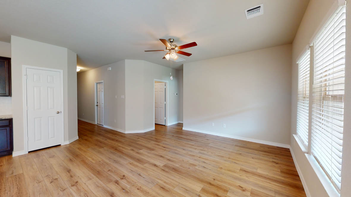 234 Water Wl Road Burnet, TX 78611 - Photo 10 of 28 an empty room with wooden floor ceiling fan and windows