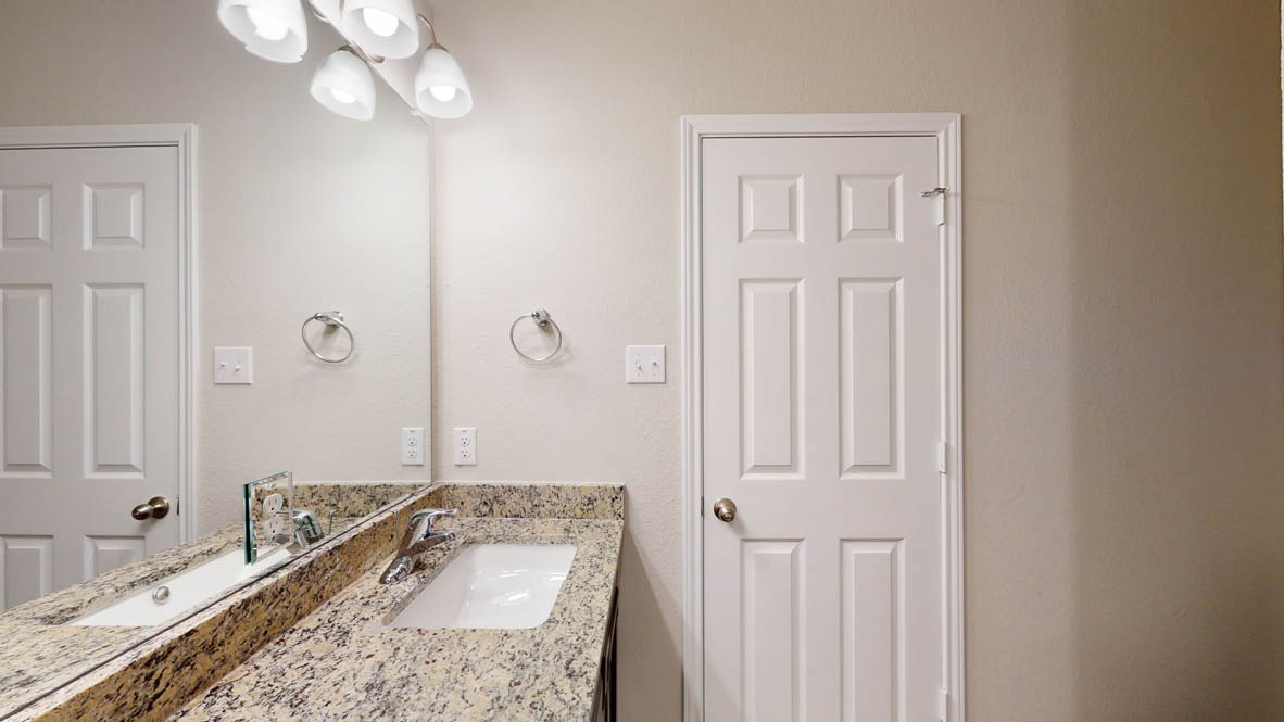234 Water Wl Road Burnet, TX 78611 - Photo 18 of 28 a bathroom with a granite countertop sink a mirror and shower