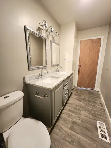 a bathroom with a toilet sink and mirror