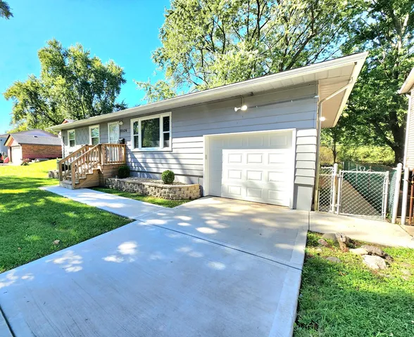 a view of a backyard with table and chairs and a large tree