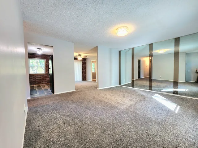 a view of a hallway with a livingroom and a bathroom