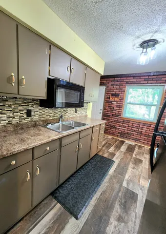 a kitchen with stainless steel appliances kitchen island granite countertop a sink stove and cabinets
