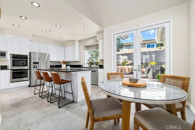 a kitchen with a dining table chairs and refrigerator