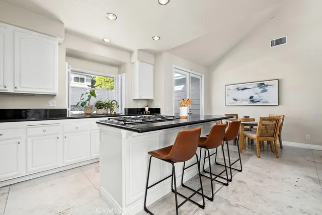 a kitchen with stainless steel appliances granite countertop a stove a sink a dining table and chairs
