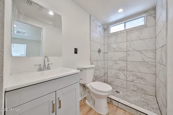 a bathroom with a sink a toilet and a mirror