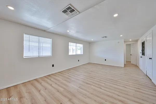 a view of empty room with wooden floor