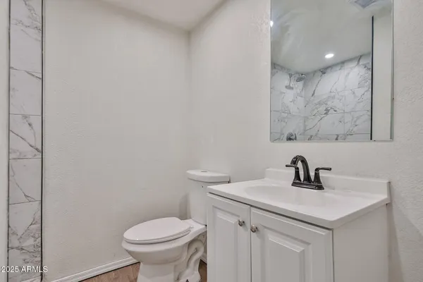 a bathroom with a toilet sink and mirror