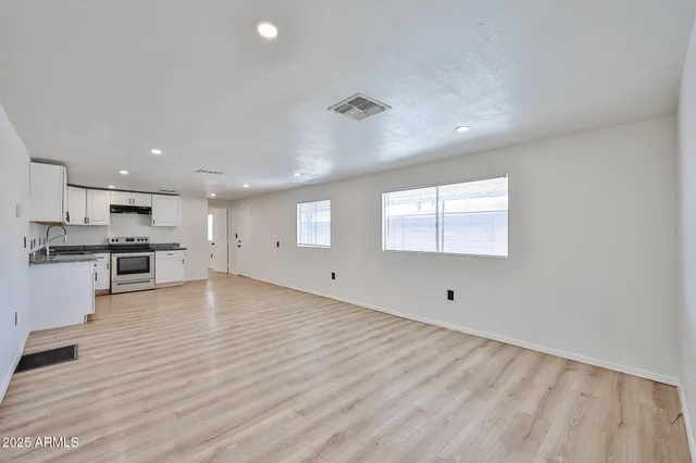 a view of empty room with wooden floor and window