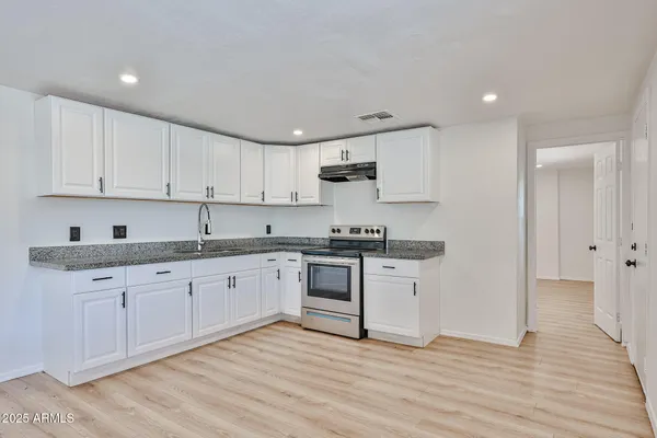 a kitchen with granite countertop white cabinets and white appliances