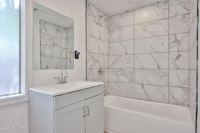 a bathroom with a bathtub sink vanity and shower