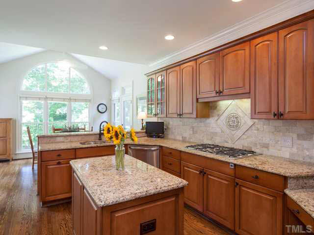 4612 White Chapel Way Raleigh, NC 27615 - Photo 10 of 25 Additional features of the updated kitchen include hardwood floors, crown molding, recessed lighting, a new faucet, new oil rubbed bronze hardware, a gas cook top with a decorative stone medallion, and a tile back splash.